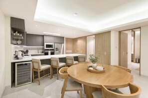 Une cuisine moderne dotée d’un îlot central, d’appareils électroménagers intégrés et d’un coin repas avec une table ronde et des chaises.