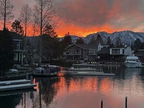 A waterfront property with docked boats, a marina, and a mountain backdrop. - Incredible Water Front Tahoe Keys Home 3BD/2BA (South Lake Tahoe)