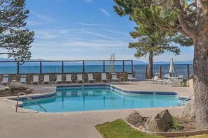 Ein Schwimmbecken mit Liegestühlen und Blick auf das Meer.