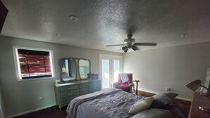 A bedroom with a bed, dresser, and a ceiling fan. - Spacious 6-bedroom house located on Richmond Lake. (Aberdeen)