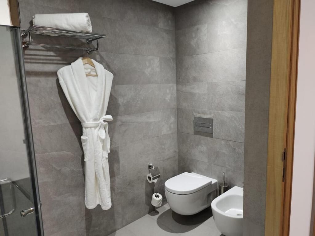 Un baño con cabina de ducha de vidrio, una bañera blanca, un inodoro y un bidé.