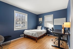 Une chambre à coucher avec un lit, un bureau et une chaise.
