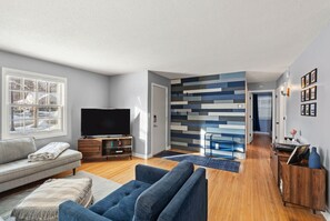 Bright, stylish living room with hardwood floors and bold accent wall - Nicollet Nook 2BR Ground-Floor Retreat (Minneapolis)