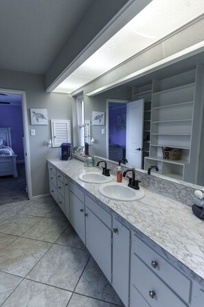 Casa de banho com duas pias, um espelho grande e um closet espaçoso.