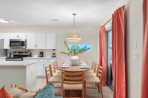 A modern kitchen with white cabinets, a built-in microwave, and a coffee maker.