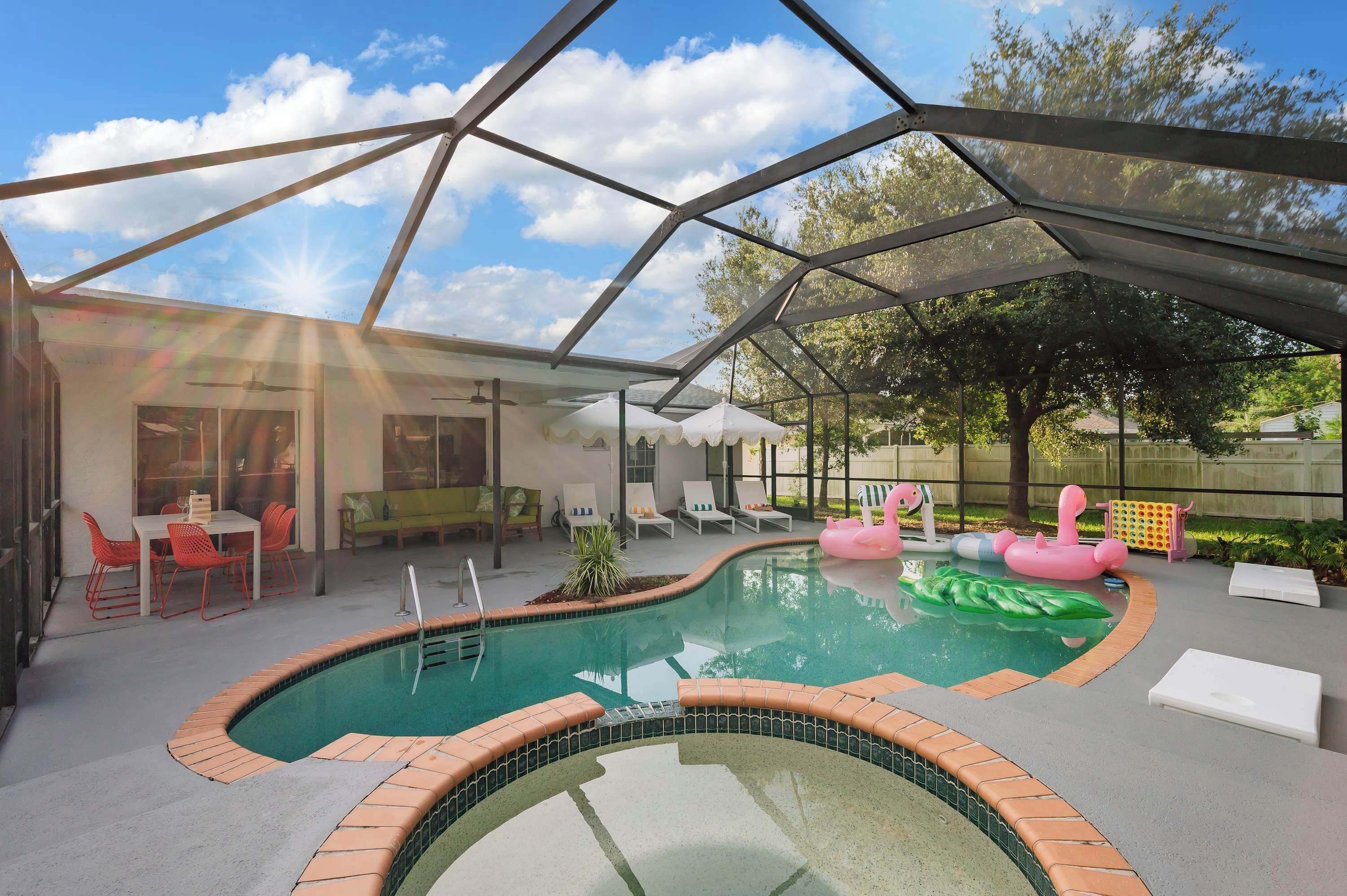 Una piscina interior con techo de cristal, rodeada de sillones de descanso y una mesita.