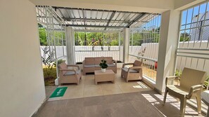 A covered outdoor seating area with wicker furniture and a potted plant. - Family home in a private residential complex (Licey al Medio)