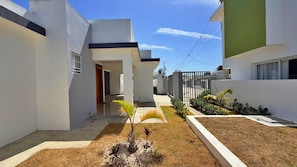 A modern residential area with clean lines, a central pathway, and a small garden with a palm tree. - Family Home in a Private Residential Complex (Licey al Medio)