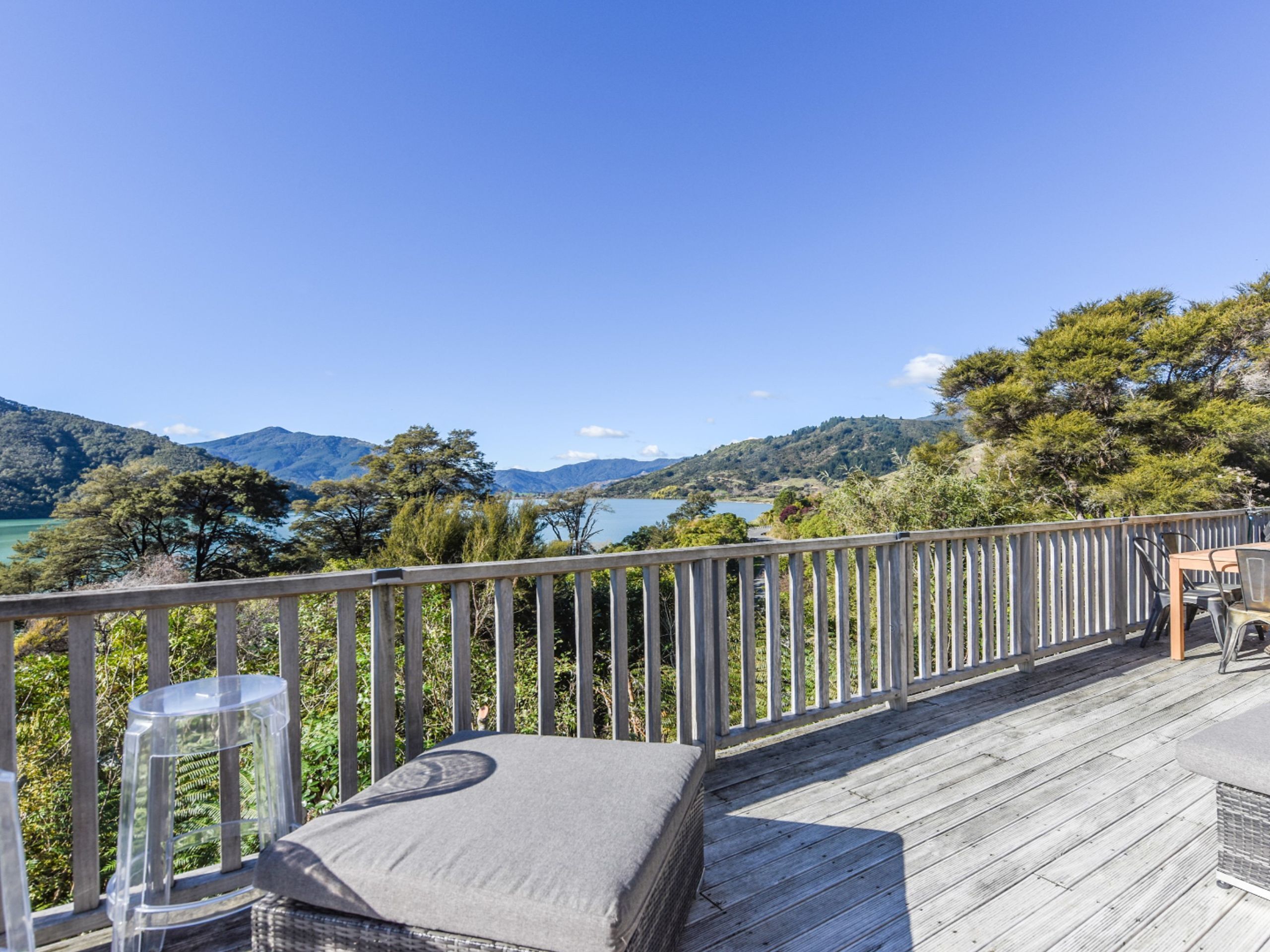 A wooden deck with a view of a lake and mountains.