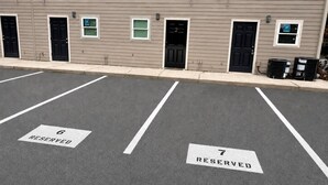 Ein Parkplatz mit zwei ausgewiesenen Stellplätzen, beschriftet mit 6 und 7, für bestimmte Zwecke reserviert.