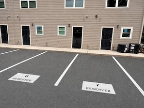 Ein Parkplatz mit zwei ausgewiesenen Stellplätzen, beschriftet mit 6 und 7, für bestimmte Zwecke reserviert.