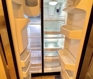 An interior view of a refrigerator with multiple shelves and compartments. - Unbelievable Townhome - Astounding location. Perfect for a long or short stay! (Gainesville)