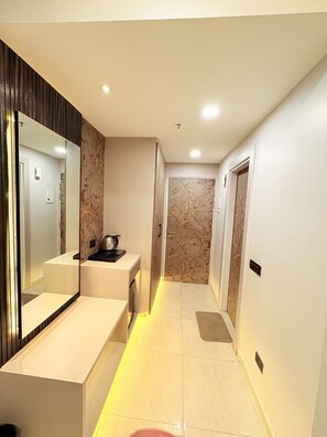 Un baño moderno con un espejo grande, un lavamanos y una zona de ducha.