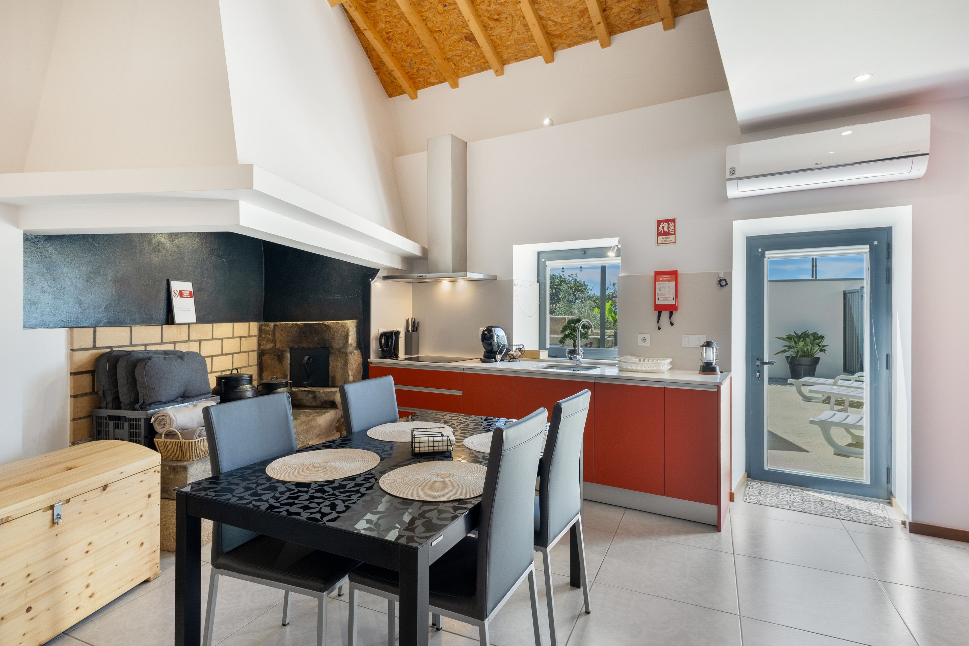 Een moderne keuken met een eethoek, een stenen openhaard en uitzicht op de omgeving.