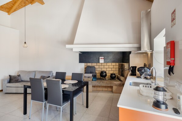 Una cocina moderna con comedor, sofá y chimenea.