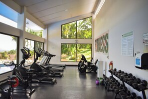 A gym with exercise equipment, large windows, and a view of greenery. - Aparmet, 2 bedrooms, gym, pool, restaurant, tennis, hot tub, Rio Oro de Santa Ana (Río Oro)