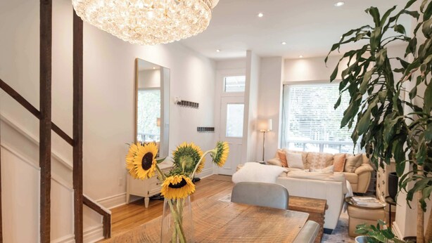 A modern living room with a dining area, a staircase, and a large window. - Charming Victorian Home | Little Italy + Garden (Toronto)