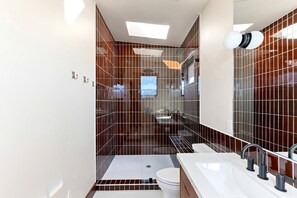 Ein modernes Badezimmer mit Dusche, Toilette und Waschbecken.