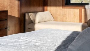 A room with a bed, a sofa, and a window. - Luxury Mid-Century Retreat with Private Hot Tub Near Capitol Reef National Park, Utah (Wayne County)