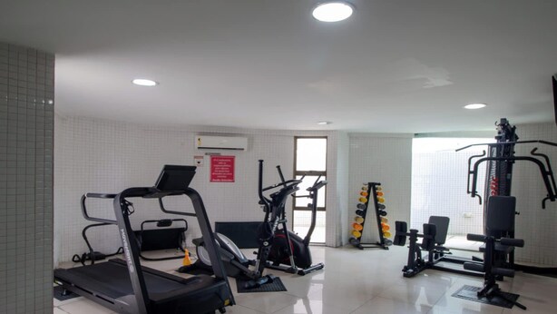 Un gimnàs amb cintes de c órrer, el·líptiques i equipament per a musculació.