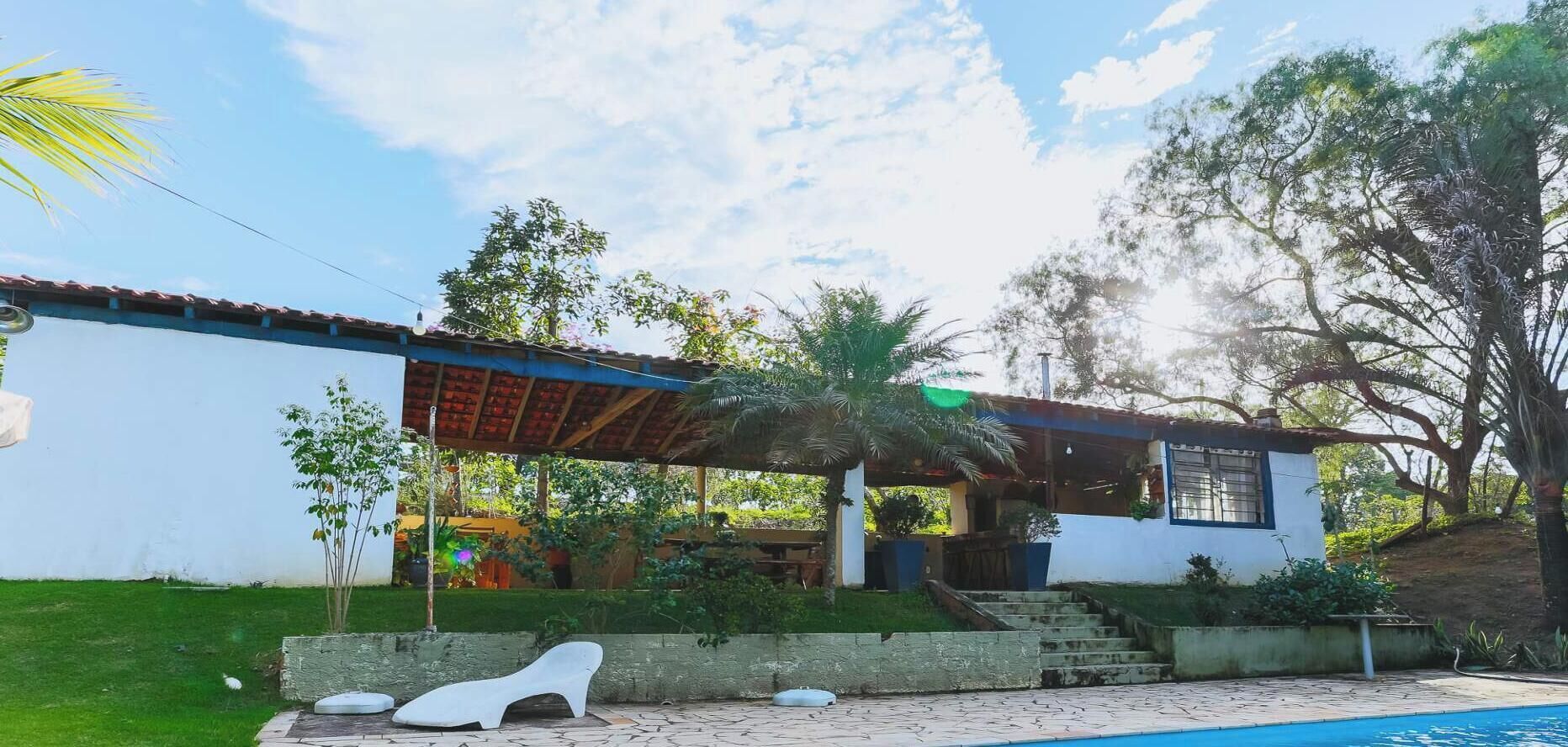 A house with a swimming pool, a covered patio, and a garden.