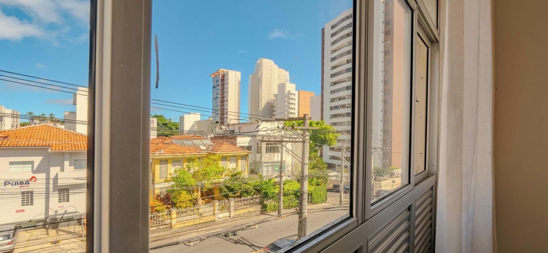 Blick aus einem Fenster auf eine Stadtansicht mit Gebäuden und einer Straße.