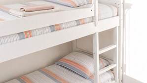 A bunk bed with striped bedding and a folded towel on the lower bunk. - Apartment with sea view in Henningsvær (Vågan)