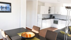 A modern kitchen with white cabinets, a dishwasher, and a stove. - Apartment with sea view in Henningsvær (Vågan)