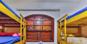 A bunk bed room with a window and a ceiling fan. - Sitio em Atibaia com piscina e churrasqueira (Atibaia)