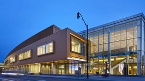 Un edificio moderno con facciata curva, ampie finestre e un ingresso ben visibile.