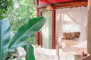 Una habitación con cama, ventana con cortinas y vistas al exterior.