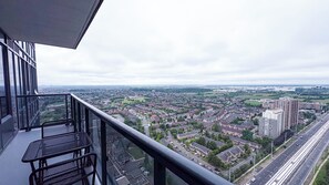 Un balcón con vistas a una zona residencial y una autopista.