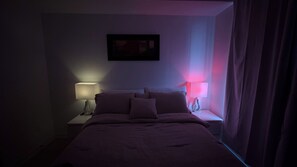 A dimly lit hotel room with a bed, two bedside tables, and two lamps. - The Chilling Spot
your private balcony, a stylish 1-bedroom, 1-bath suite. (Mississauga)