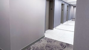 A hotel hallway with a patterned carpet, doors numbered 31, and a ceiling light.