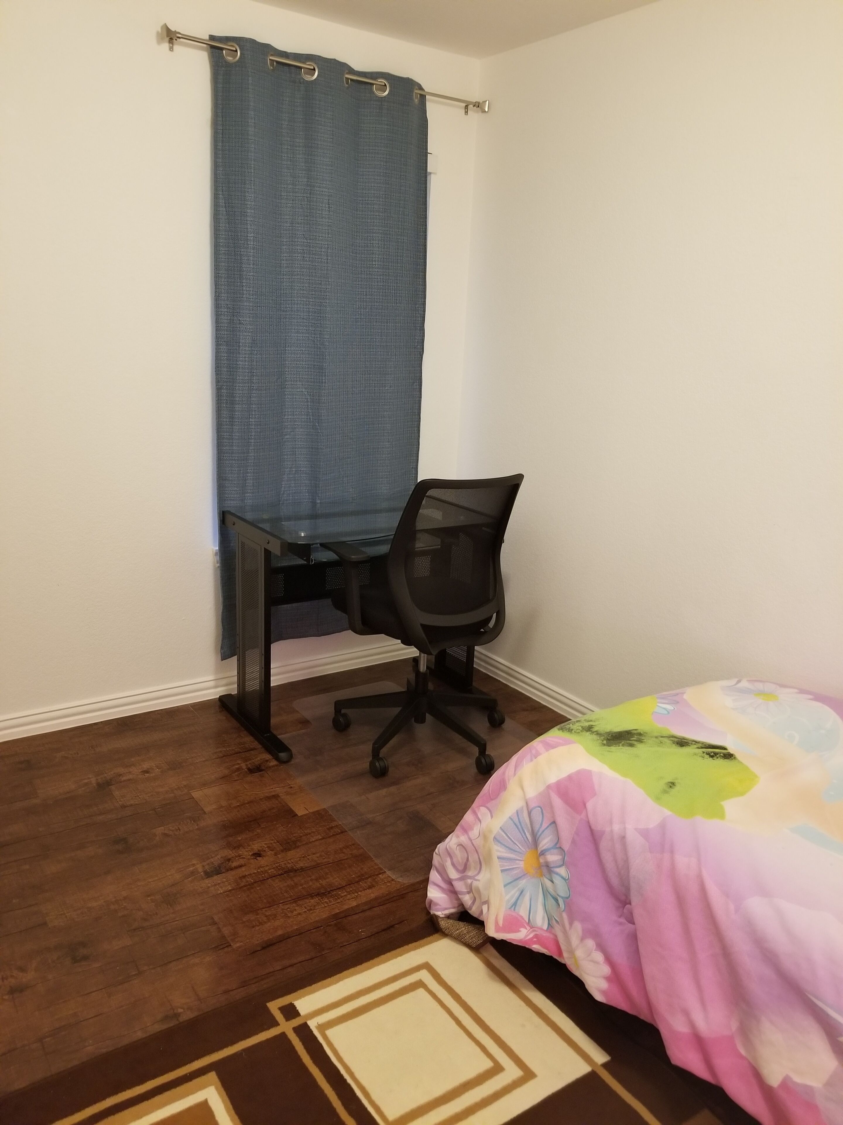 Un dormitorio con cama, escritorio y silla.