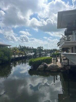 A marina with boats docked, a clear sky, and a calm water body reflecting the surroundings. - New 4 bed 3 bath house on Ramrod Key (Ramrod Key)