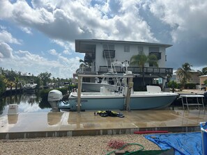 A marina with boats docked, a building with a balcony, and a clear sky. - New 4 bed 3 bath house on Ramrod Key (Ramrod Key)