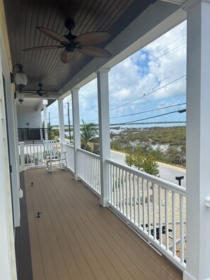A covered porch with a view of a water body and vegetation. - New 4 bed 3 bath house on Ramrod Key (Ramrod Key)
