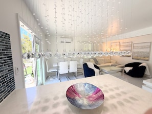 A modern interior with a central island, hanging lights, and a dining area. - Short Walk to Beach • 3BR Poolside Unit • Next to Nature Preserve (Fort Myers Beach)