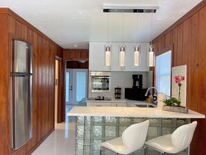 A modern kitchen with a central island, stainless steel appliances, and pendant lighting. - Big Groups,Nature View Estates 3 units private pool, WALK TO BEACH (Fort Myers Beach)