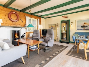 A cozy living room with a fireplace, comfortable seating, and a television. - 8 Person Holiday Home in Martofte (Martofte)