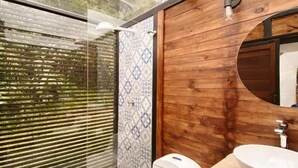 A modern bathroom with a wooden vanity, a white sink, and a toilet.