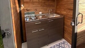 A compact kitchen with a microwave, sink, and cabinets.