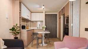 A compact living space with a kitchenette, a dining area, and seating. - Eleuterio Ramirez Apartments by Andes (Santiago)