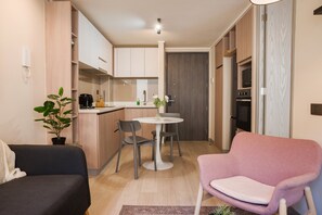 A compact living space with a kitchenette, a dining area, and seating. - Eleuterio Ramirez Apartments by Andes (Santiago)