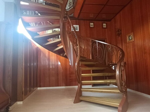 A spiral staircase with ornate metal railings in a wooden interior.