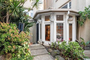 A corner building with a bay window, stone steps, and surrounding greenery. - Rosa and Noir Riverside Escape near Botanic Gardens (South Yarra)