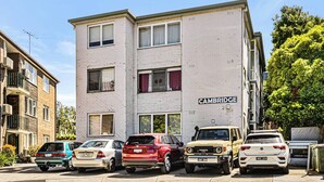 Un immeuble à plusieurs étages dont la façade porte une enseigne indiquant « CAMBRIDGE ».