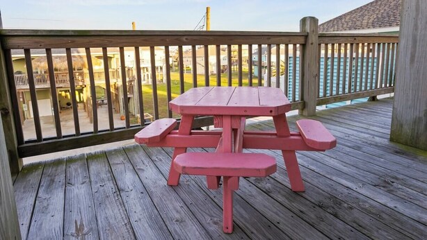 A wooden deck with a picnic table and benches. - Coastal Escape - Beach Access - Pet Friendly (Bolivar Peninsula)