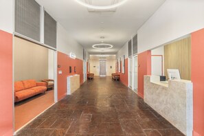 A hotel lobby with a reception desk, seating area, and a corridor leading to the entrance. - VCAY - Bridge View 5BR-5BA  (New Orleans)